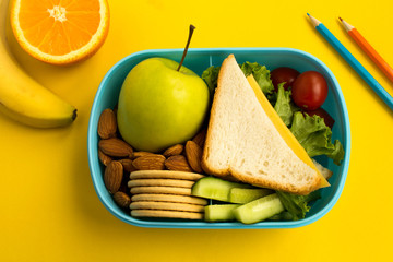 School lunch in the box on the yellow background.Top view.