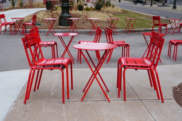 A set up of red chairs waiting for the customers during a cold day of April.