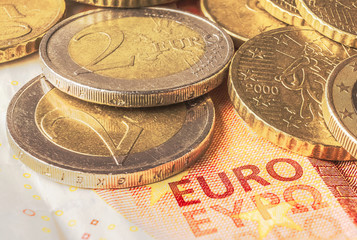 Some coins of euro on a banknote of ten euros. Finance and business concept.