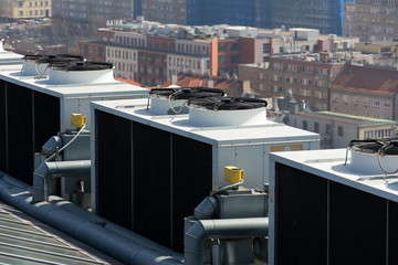 Air conditioning ventilators on roof with houses in background