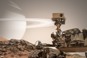 Curiosity Mars Rover exploring the surface of red planet. Elements of this image furnished by NASA.