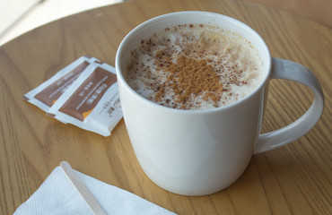 Cup of cappuccino on wood tab in coffee shop