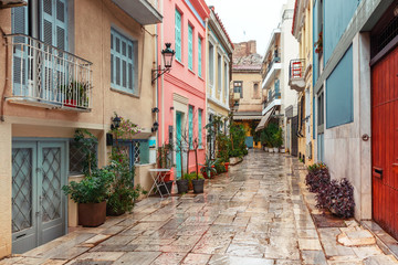 Beautiful cosy narrow street with stairs in famous Placa district in the rainy day, Old Town of Athens, Greece - obrazy, fototapety, plakaty