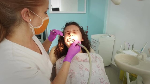 Female Dentist Using Dental Drill