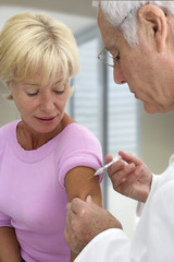 Obraz na płótnie Canvas Doctor injecting vaccine to senior woman