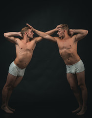 Fototapeta na wymiar Twins men with muscular body in balance pose. Circus gymnasts at pilates or yoga training. Sport workout for bodybuilder. Fitness dieting and flexibility in acrobatics. Friendship of men do gymnastic
