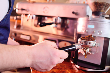 Holder with ground coffee close-up in the hands of baristas or coffee bartenders