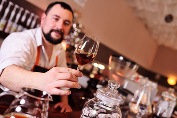 barista or coffee barman prepares coffee by an alternative method of brewing - pour over - by hot water spilling through a special filter with ground powder