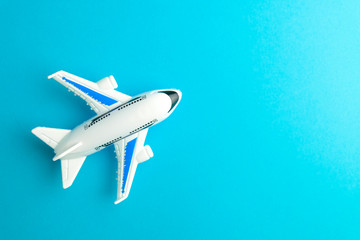 Close-up white plane toy on blue background.  Concept of traveling