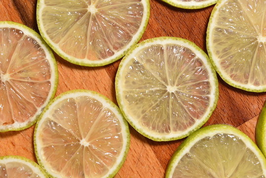 Fresh and bright sliced lime on a wooden surface