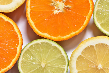 Fresh sliced lemon, lime and orange on a white surface