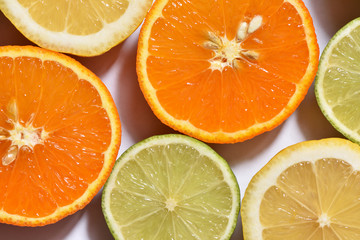 Fresh sliced lemon, lime and orange on a white surface