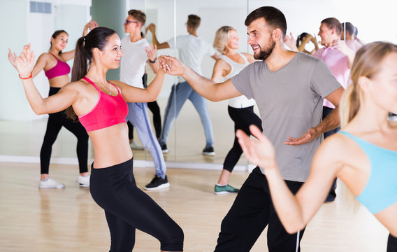 dancing couples of young men and women learning swing