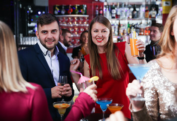 Woman with colleagues on corporate party in bar