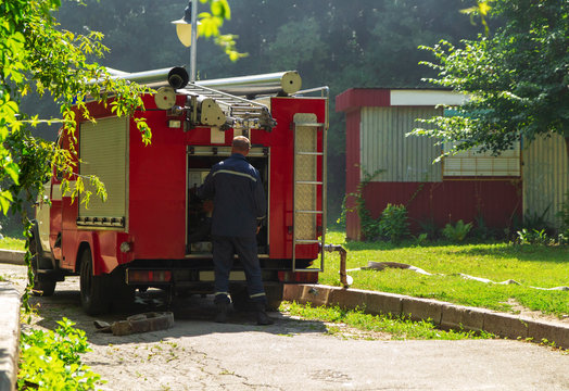 Firefighter is preparing the gear for firefighting, rescue, red firefighting car