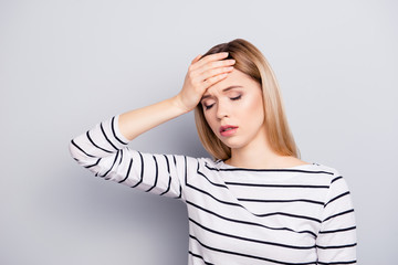 Portrait of sad, upset, blonde, unhappy, charming, pretty girl touching her forehead with palm...