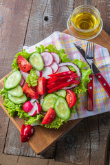 Vegetable mixed salad in a plate and olive oil.