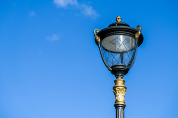 Fototapeta na wymiar Vintage lamp post close-up over blue sky