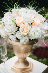 Wedding arch decorated with cloth and flowers outdoors. Beautiful wedding set up. Wedding ceremony on green lawn in the garden. Part of the festive decor, floral arrangement.