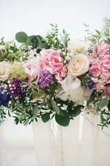 Wedding arch decorated with cloth and flowers outdoors. Beautiful wedding set up. Wedding ceremony on green lawn in the garden. Part of the festive decor, floral arrangement.