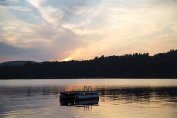 Fototapeta na wymiar Metal swim platform, Squam Lake, New Hampshire, at sunset