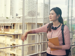 Young Asian female student with notebooks in her hands.A portrait of an Asian college student.education and learning concept