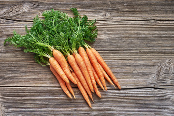 Organic food. Red carrots in the on rustic wooden background. Top view, copy space.