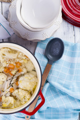 Cauliflower cooked in a red cast iron. A blue towel. Free space for text. Family dinner. Dietary food