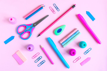 Pink desk with variety of rose and blue school supplies. Back to school minimalism concept. Top view