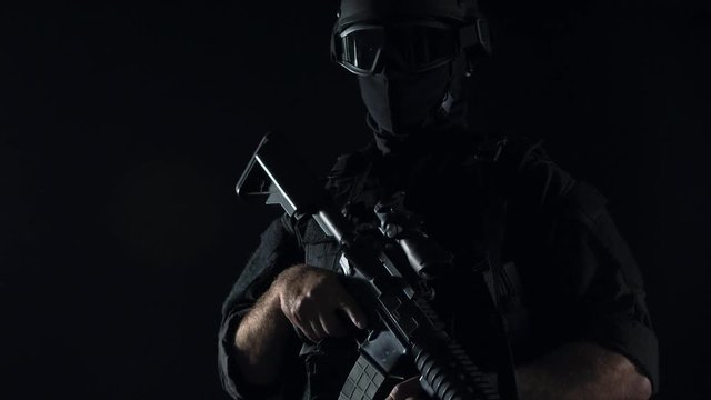 Spec ops police officer SWAT in black uniform studio