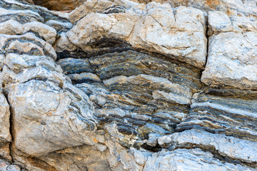 Compressed rock layers formation in various colors and thicknesses, on south central coast of the  Mediterranean island Crete, Greece. Nature and Geological science concept