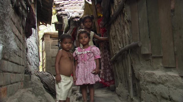 Children in Calcutta alley posing for portrait as mother looks on