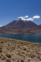 miscanti volcano with snow and its lagoon at andes mountain range - vertical