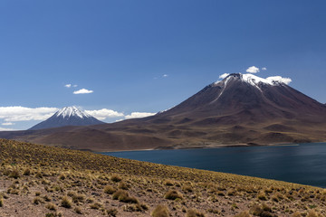 miscanti volcano with snow and its lagoon at andes mountain range