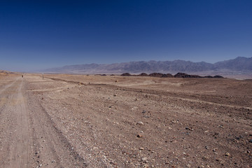 Fototapeta na wymiar Way in the desert in the Israil in sunny day with red mountains and blue sky