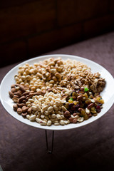 Large white plate on a stand with nuts raisins and dried fruits