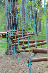 Fototapeta na wymiar Adventure rope park at spring, summer. Different ladders, wooden bars. Active and sport lifestyle