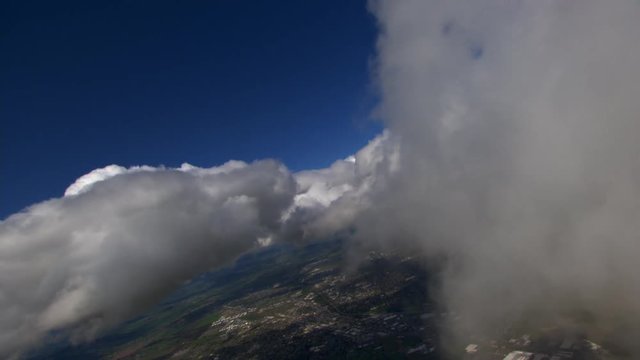 Teetering flight through patchy clouds above town