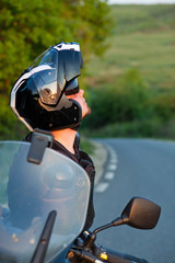 rider on a motorcycle taking a break to admire the landscape - summer road trip on a motorbike