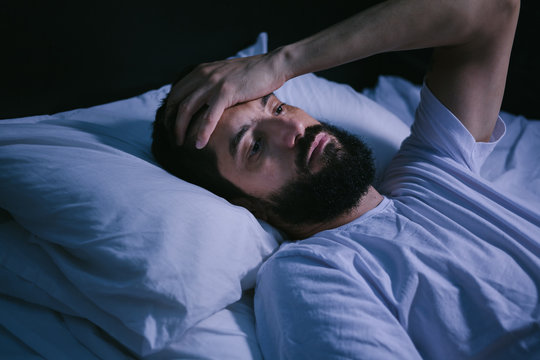 Young Man In Bed With Eyes Opened Suffering Insomnia And Sleep Disorder