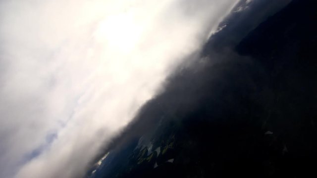 Steeply tilting flight through gray clouds