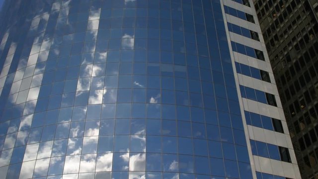 Time-lapse view of reflected clouds on frame-filling skyscraper exterior in NYC