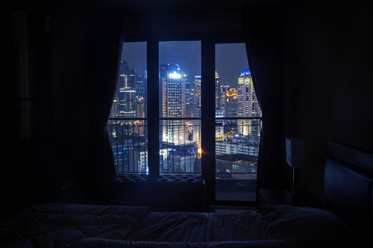 Fototapeta Dark bedroom with light on the skyscrapers