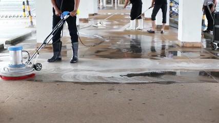 Asian worker cleaning sand wash exterior walkway using polishing machine and chemical or acid