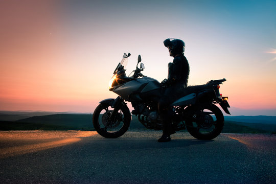Fototapeta man on his motorbike admiring sunset - summer road trip - space for text