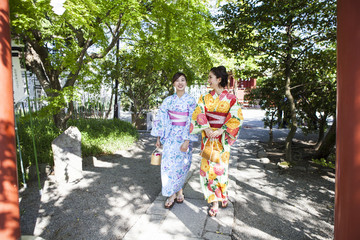 浴衣女性たちは神社の参道を歩いている