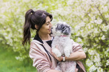 Beautiful Woman Hugging  Her Cute Dog in the Spring park.Pet and Owner Outdoor