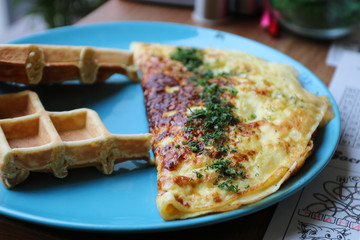 Breakfast. Omelette with herbs and waffles.