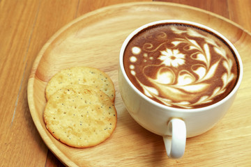 Hot coffee latte decorated on wooden background.