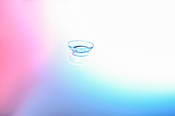 Contact lens on color glass background